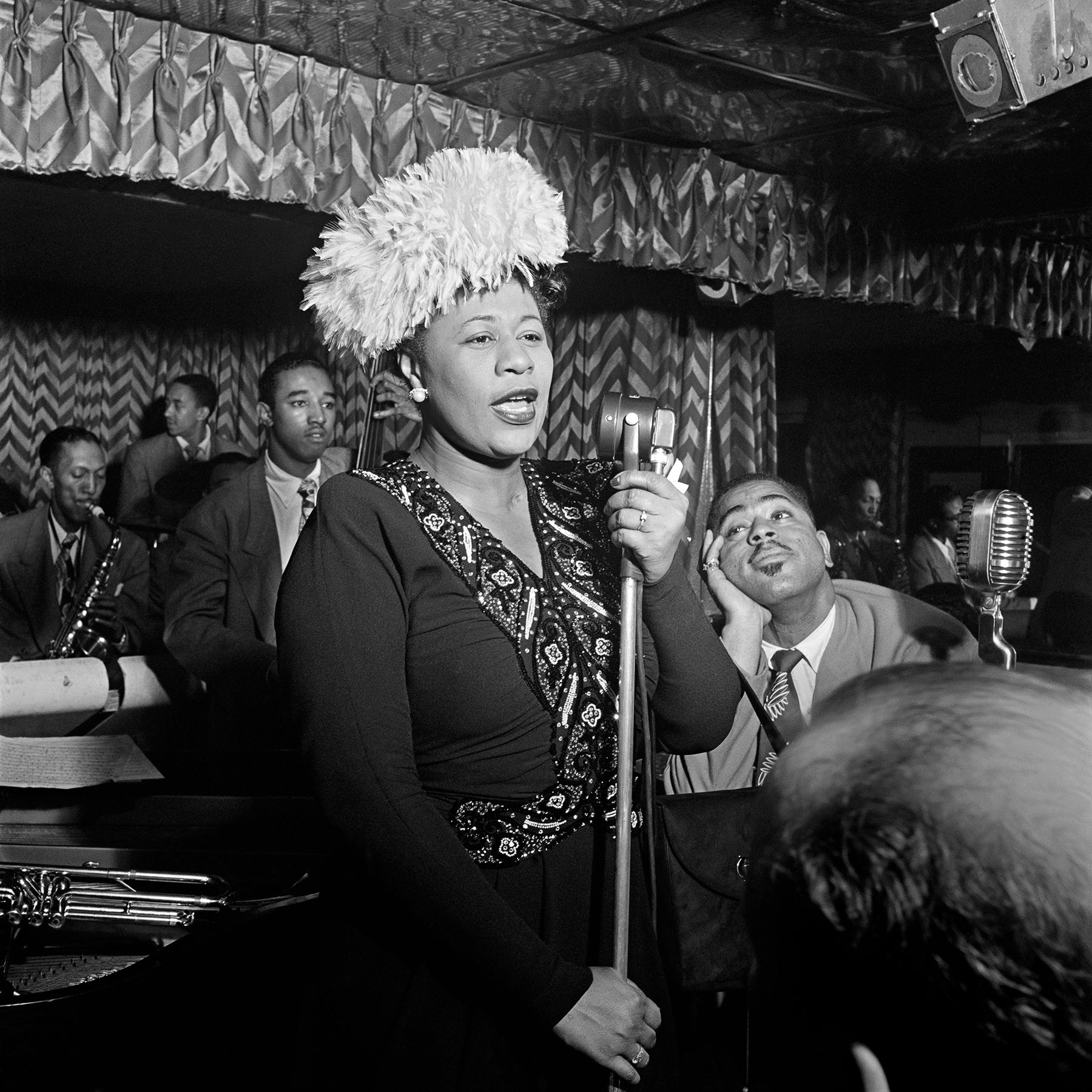 A vintage, black and white photograph of Ella Fitzgerald performing