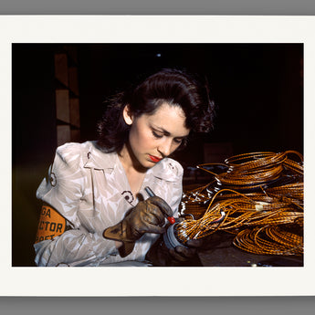 A reproduction print on paper of a vintage photograph of a female aircraft worker