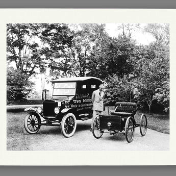 A paper reproduction print of a photogrpah of Henry Ford with the first and ten millionth Fords