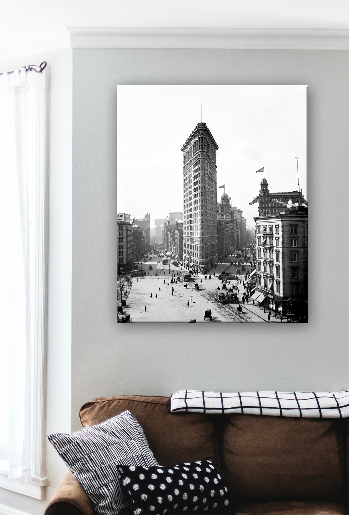 A photo of the Flatiron Building in New York City, rendered as a canvas print hanging on a living room wall