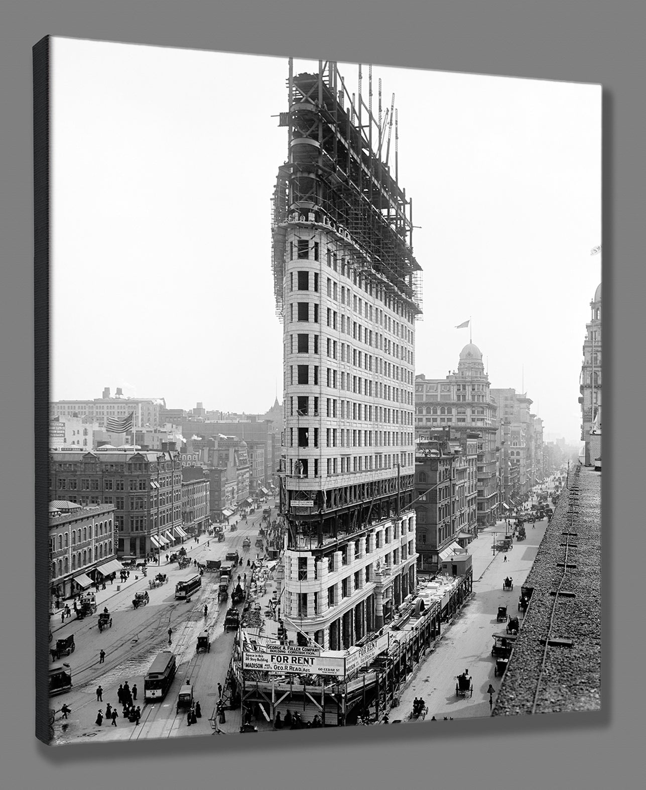 A canvas print digital mockup featuring a vintage photograph of the Flatiron Building in New York City while under construction