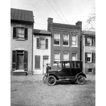 A vintage photograph of a Ford vehicle parked outside the Spite House in Old Town, Alexandria