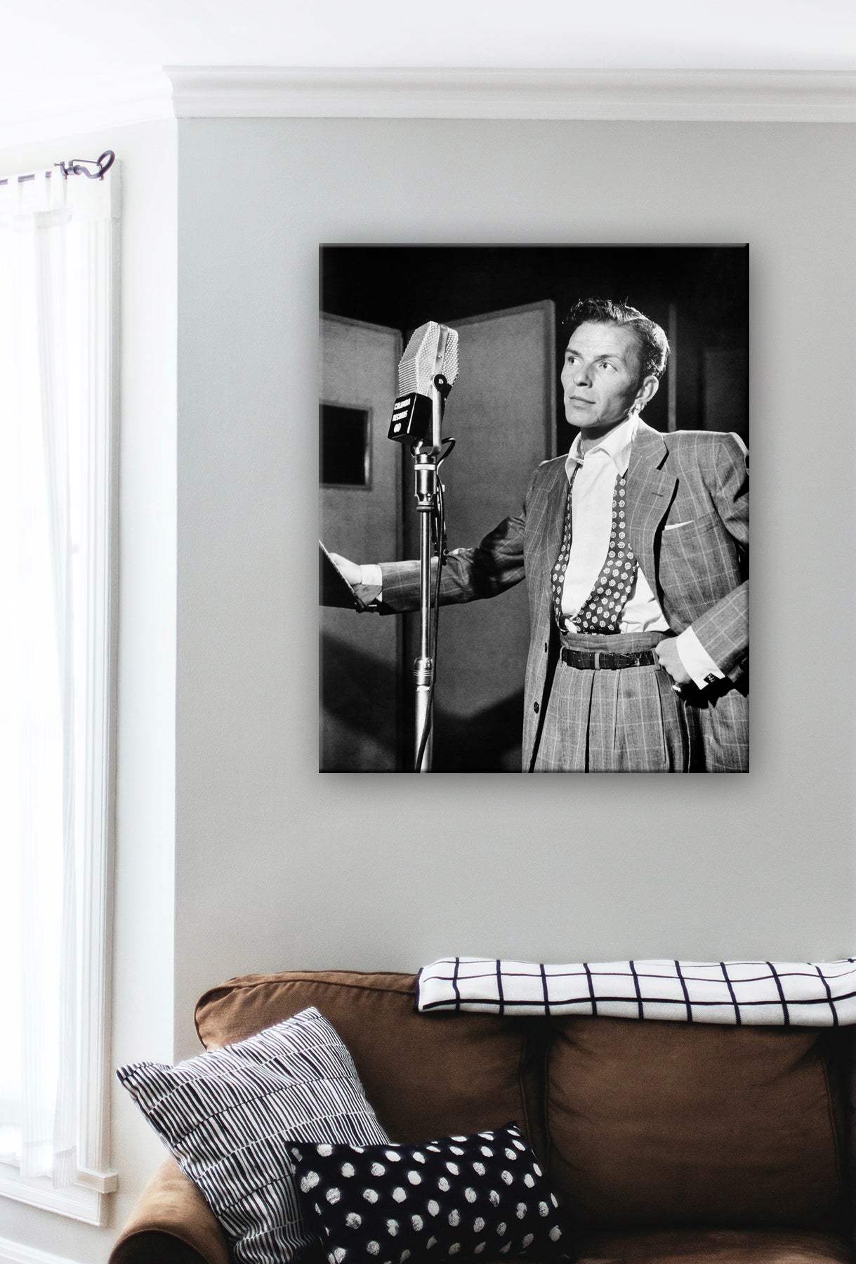 A digial mockup of a canvas print of Frank Sinatra hanging on a wall above a brown couch