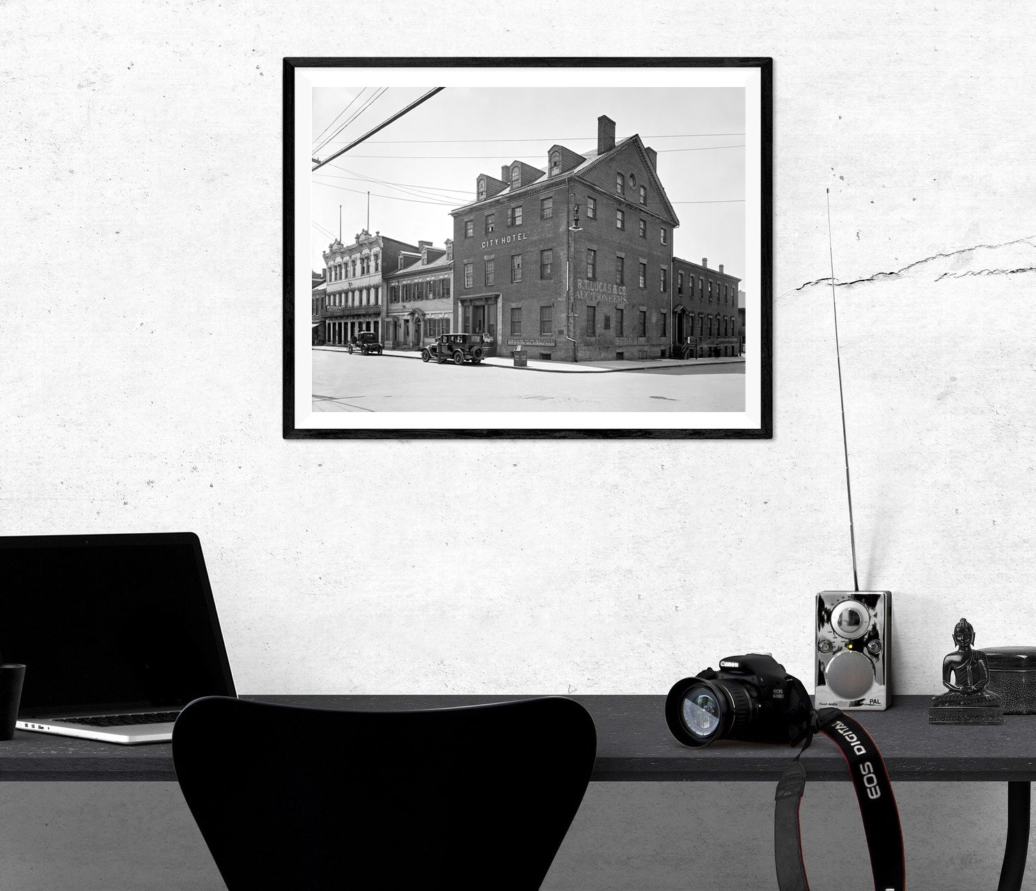 An office with a framed paper print of a vintage photograph of Gadsby's hanging above the desk