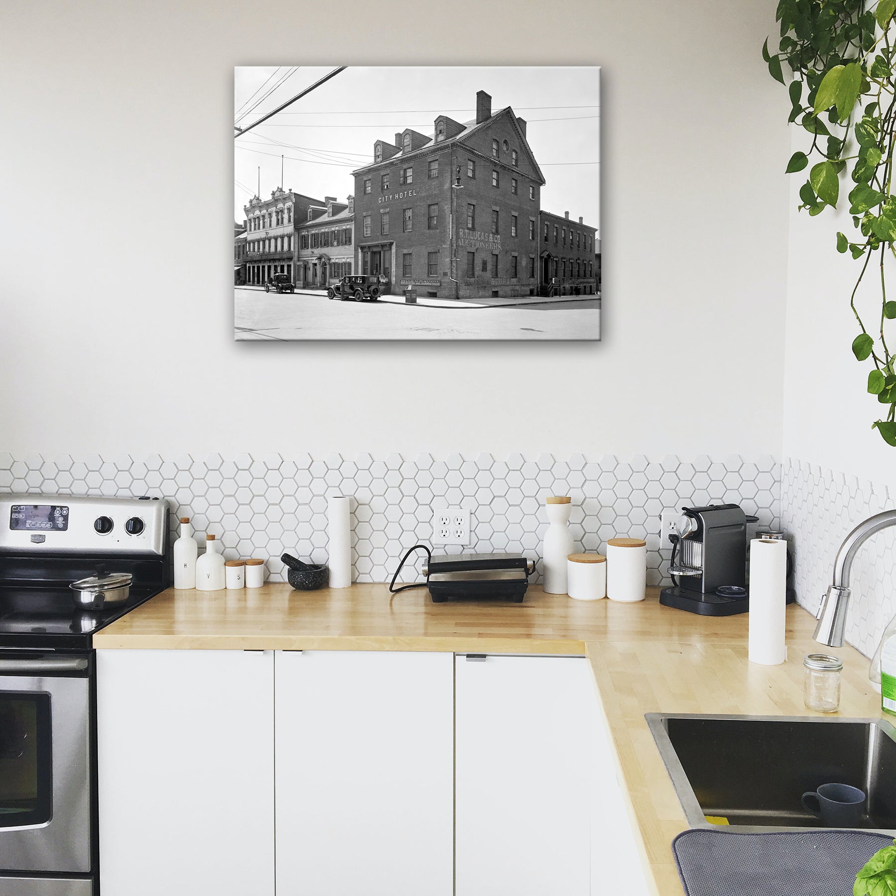 A sleek kitchen with a canvas print on the wall, featuring vintage photography of Old Town