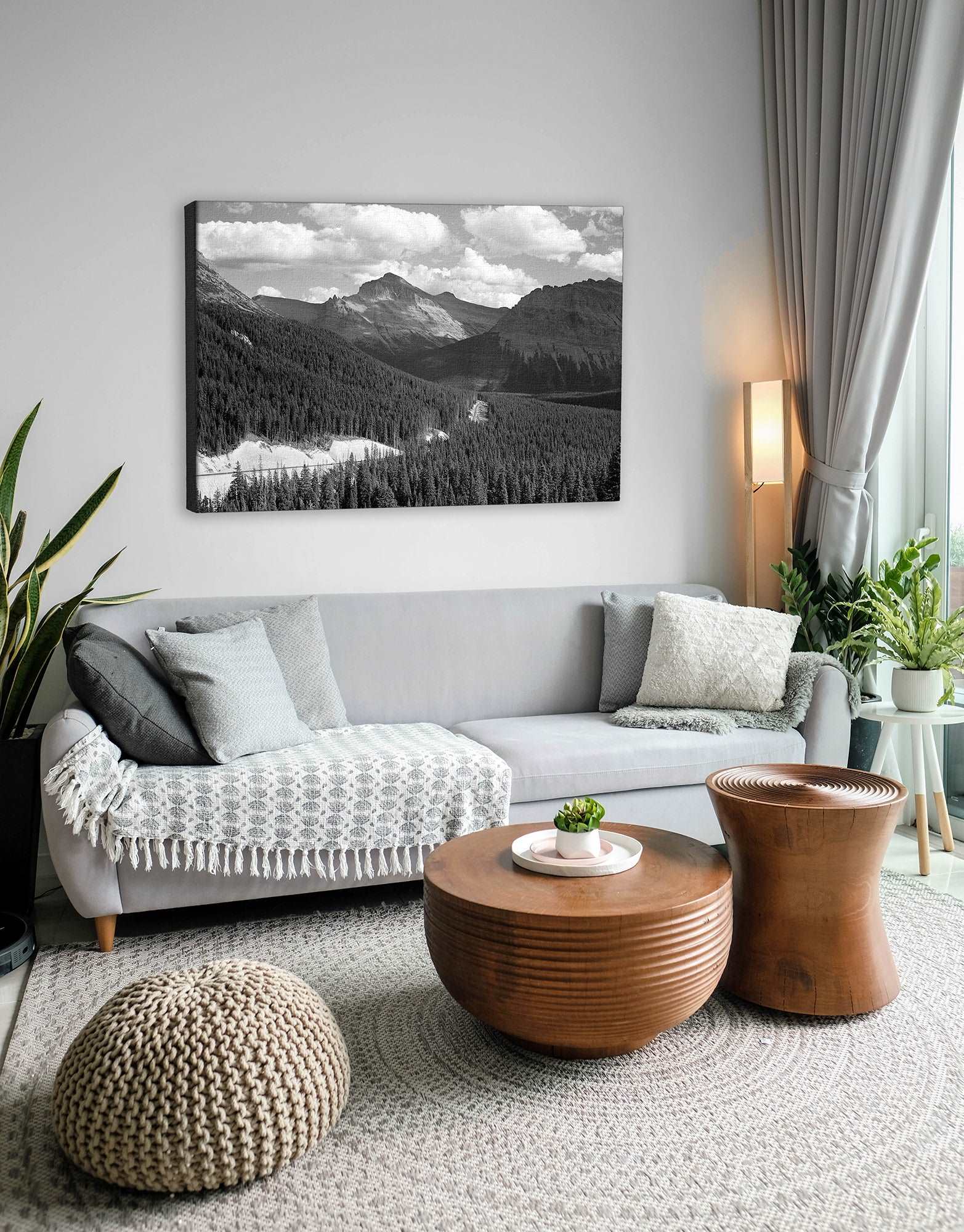 A canvas reproduction print of a landscape photograph of Glacier National Park hanging above a couch