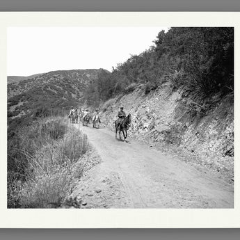 A fine art paper print of vintage photography of a group on horseback on a trail