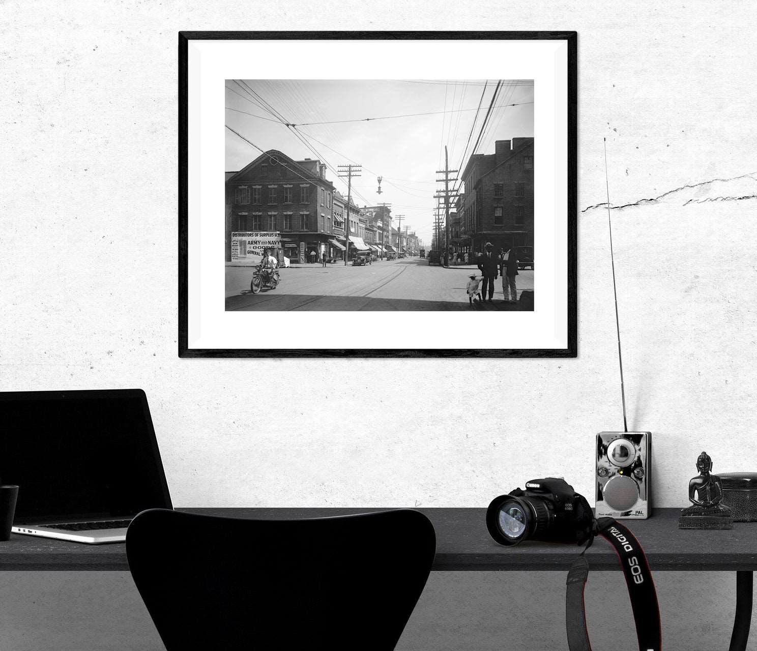 A framed paper print hanging above a desk, featuring vintage photography of Old Town's King Street