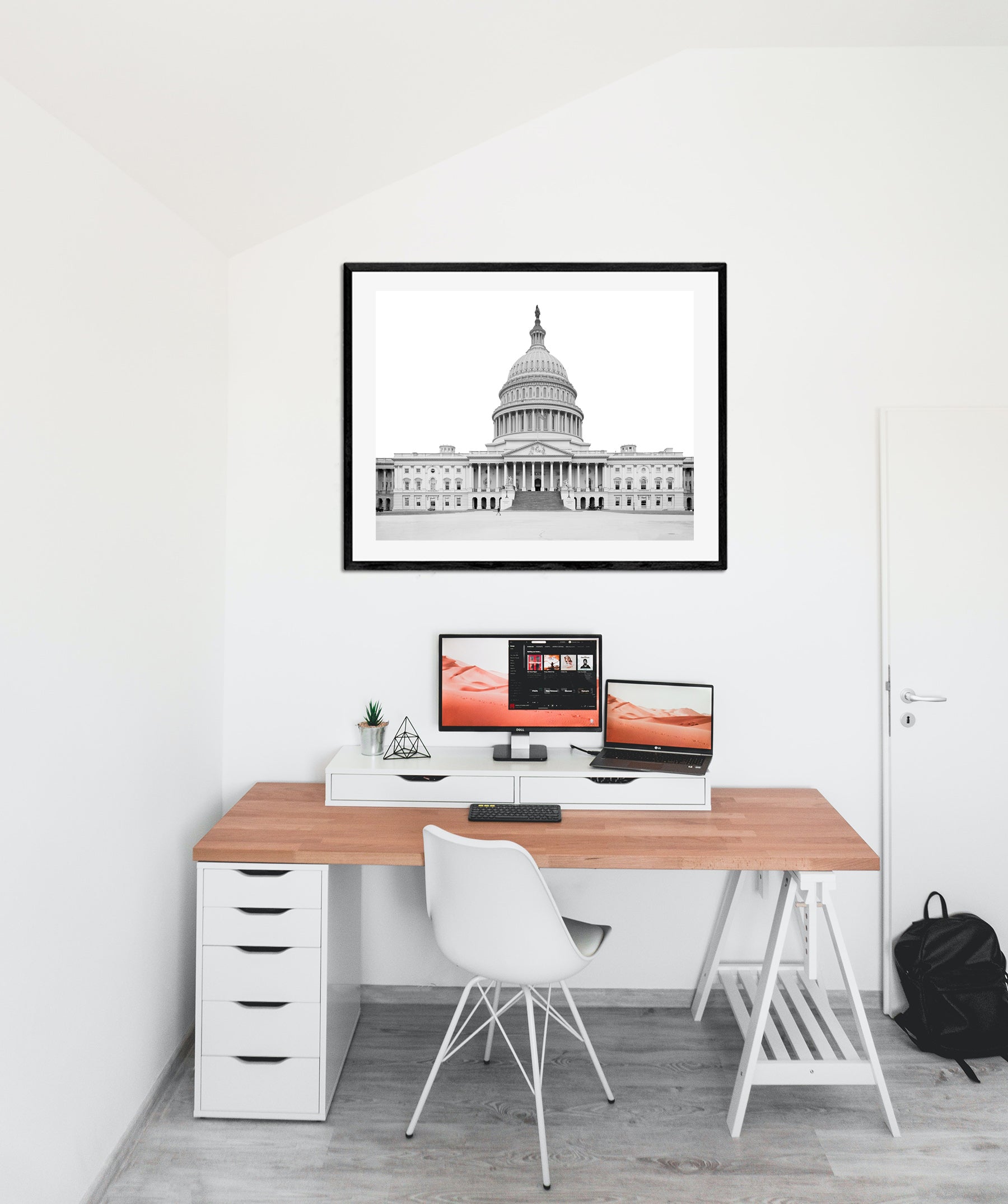 A framed paper print hanging in an office, featuring a black and white photo of the Capitol Building