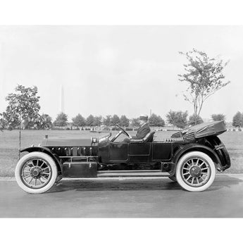 A vintage photograph of a man sitting in a car made by Marmon Motor Car Company