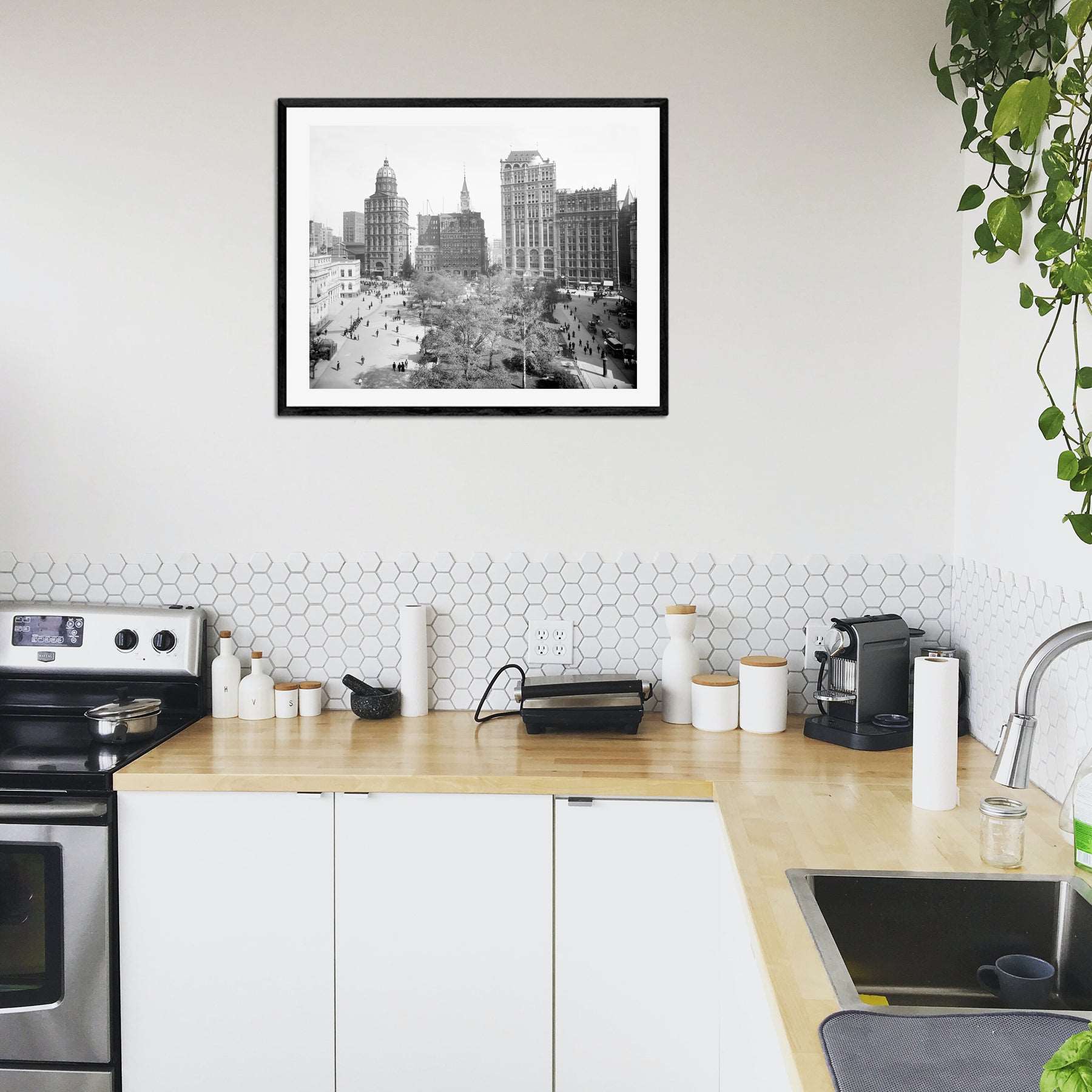 A framed paper print of a photograph of New York City hanging in a kitchen