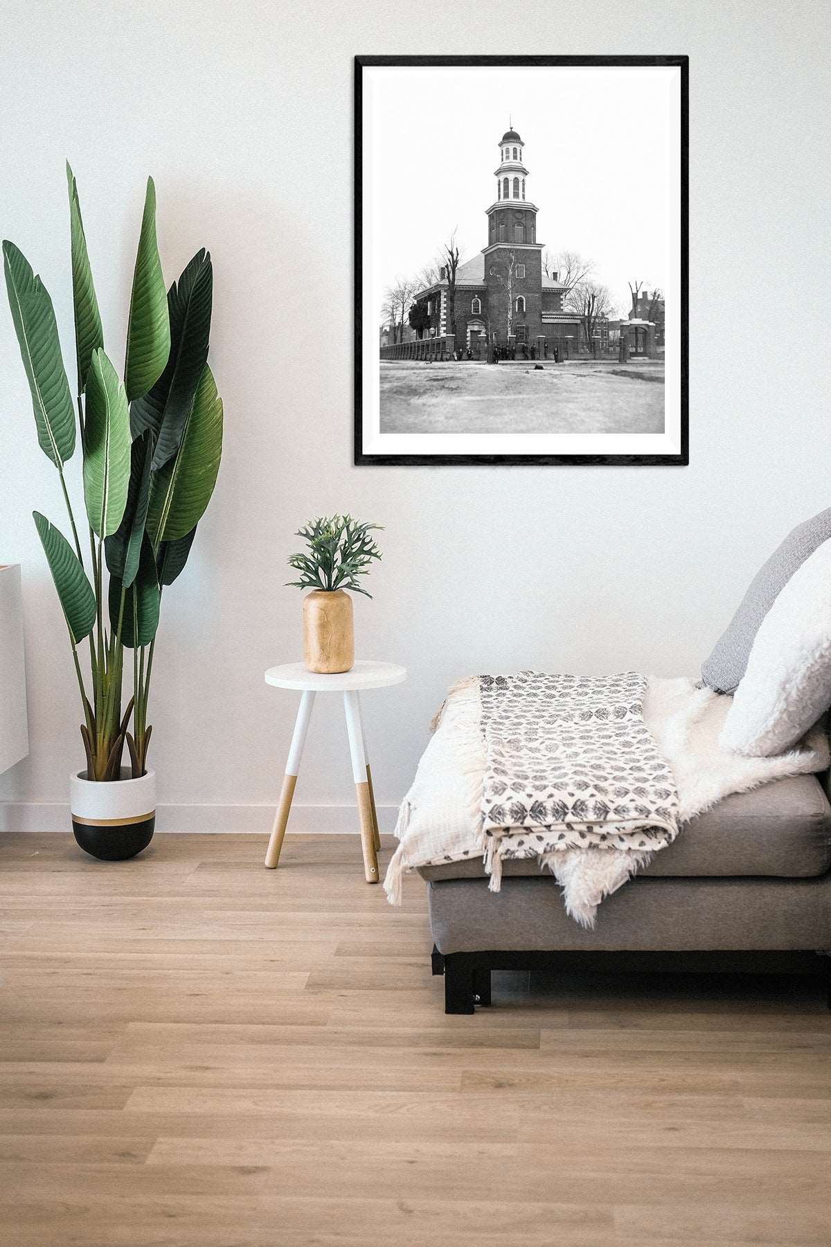 A photo of a living room with a framed print on the wall, featuring vintage photography