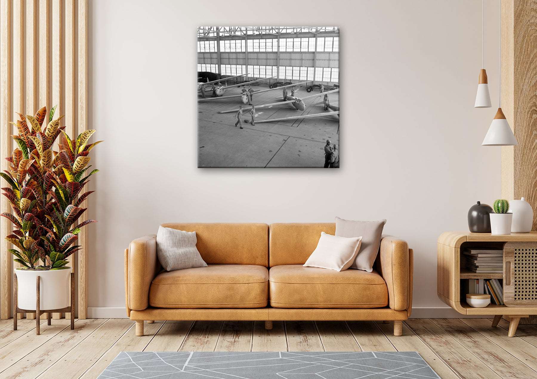 A warm toned living room with a canvas print on the wall, featuring a vintage photogrpah of military planes