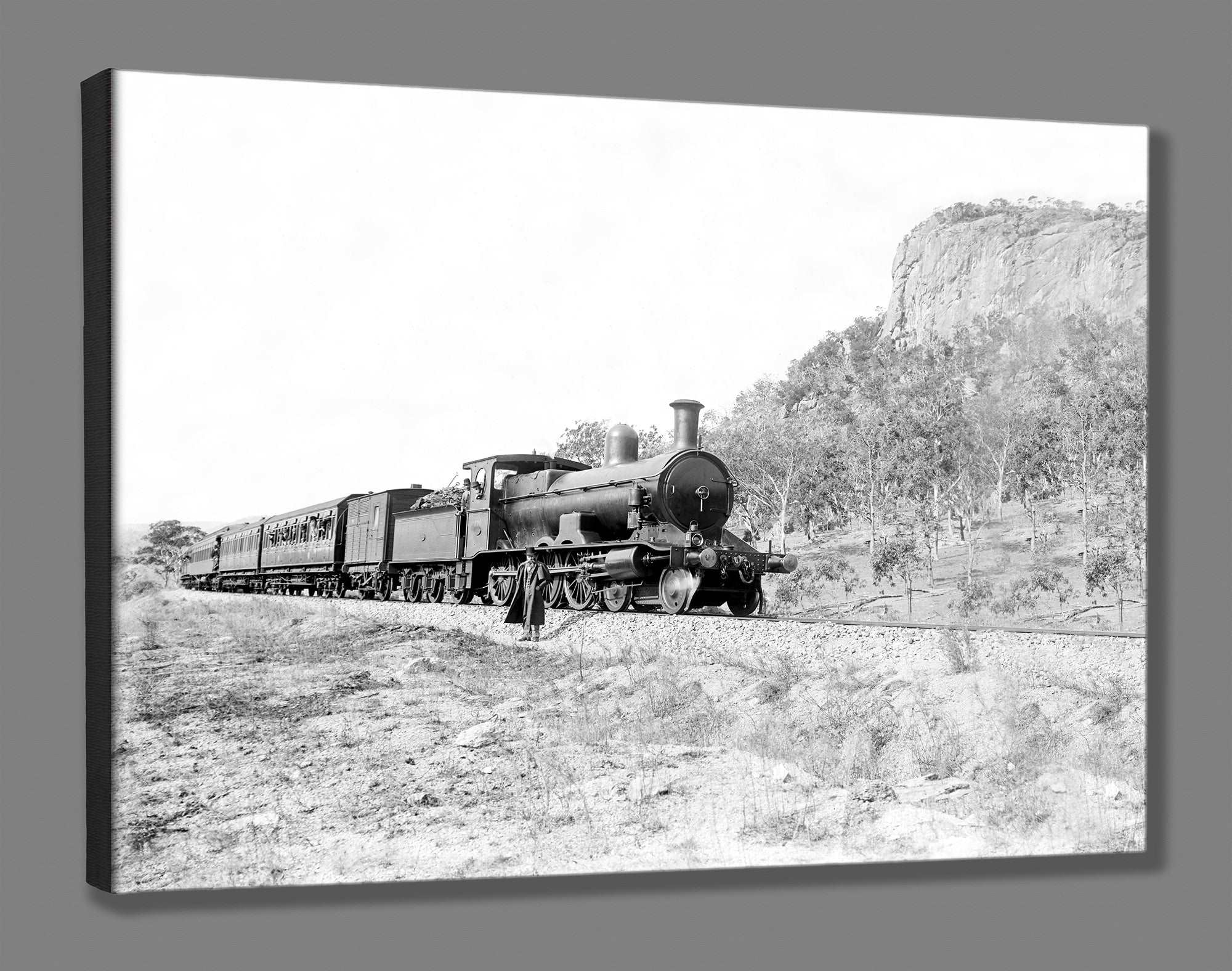 A canvas print reproduction of a photograph of a man standing beside a train
