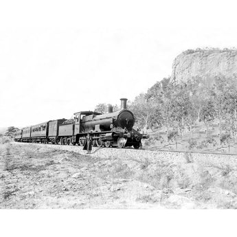A vintage photograph of a man standing beside a passenger train
