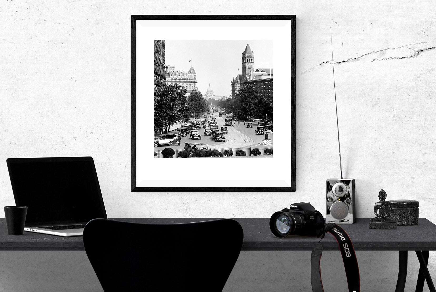 A framed print of Pennsylvania Avenue hanging on a white wall above a desk