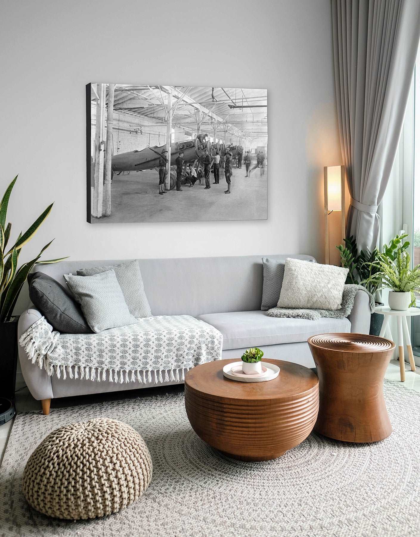A photograph of a living room, with a canvas print on the wall, featuring vintage photography