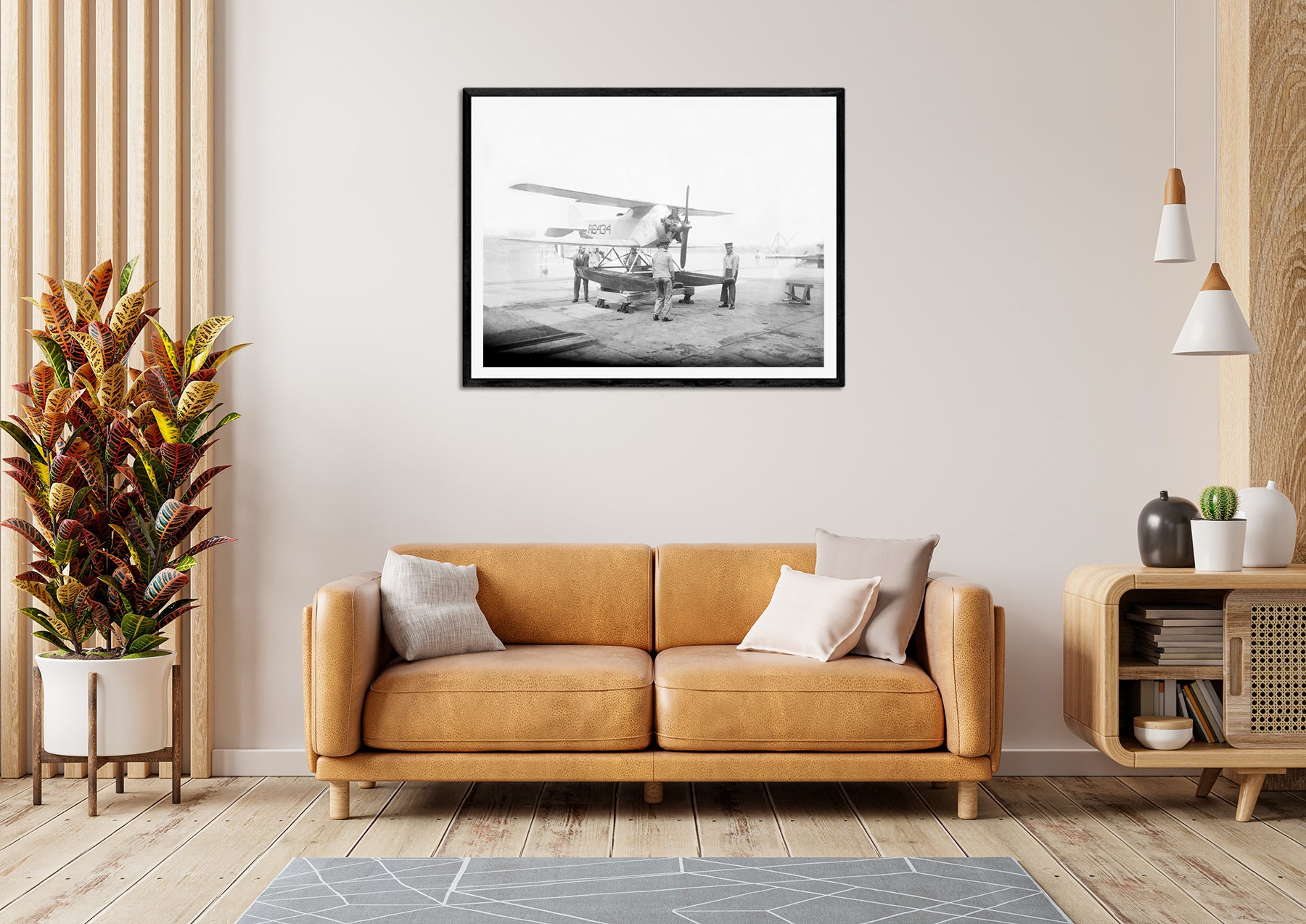 A framed paper print of a photograph of a submarine plane hanging above a yellow couch