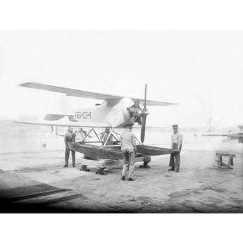 A vintage photograph of several men standing around a submarine plane