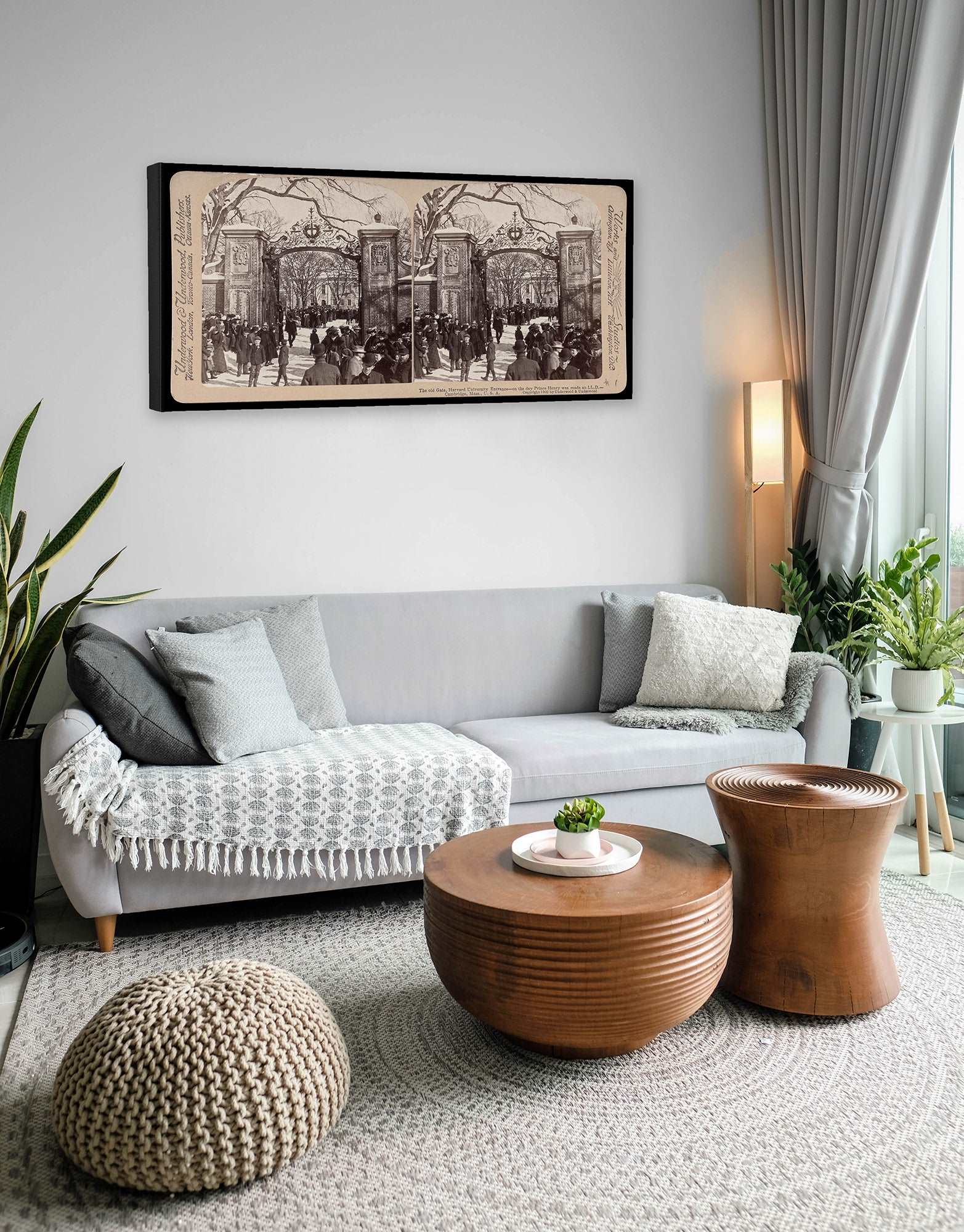 A photograph of a canvas print reproduction of a vintage stereograph image hanging above a couch