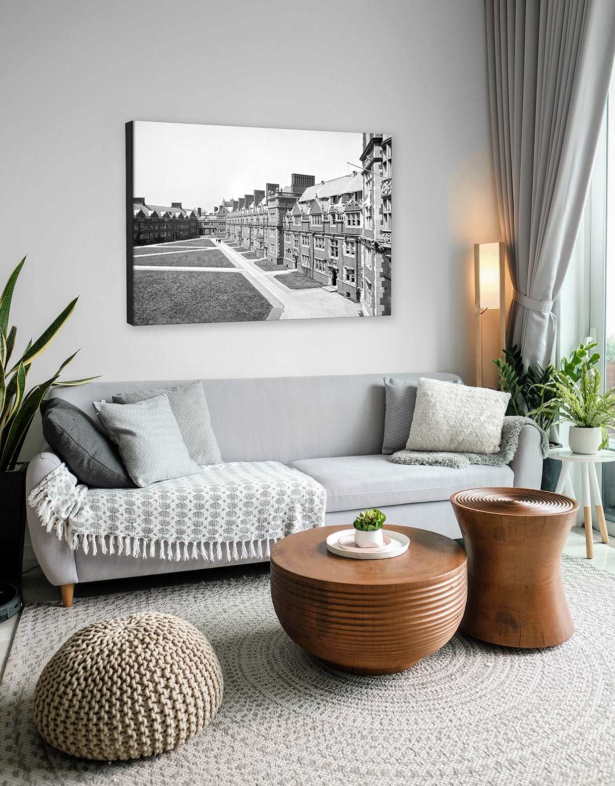A photograph of a neutral living room with a canvas print of vitange photography above the couch