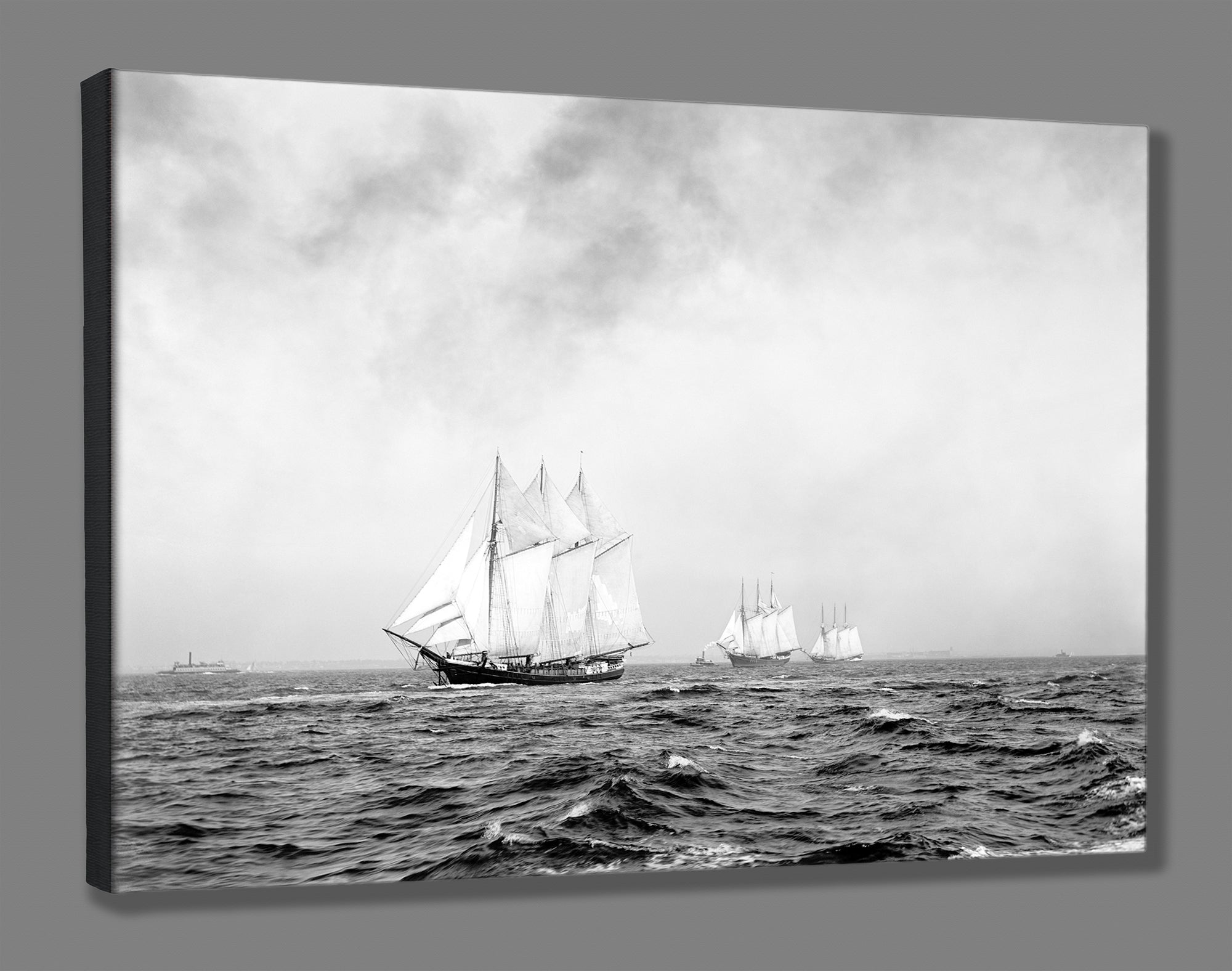 A canvas reproduction of a black and white photogrpah of three ships sailing on the ocean