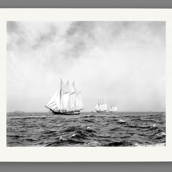 A paper print reproduction of a photograph of a group of three-masted ships on the ocean