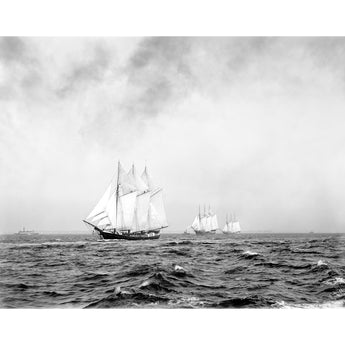 A vintage photograph of a trio of three-masted ships sailing on the ocean