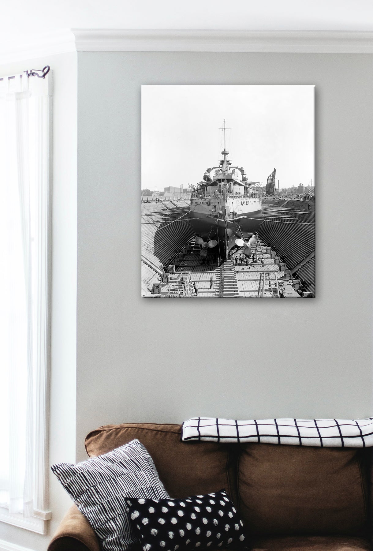A canvas print of the USS Oregon in Dry Dock hanging above a brown couch