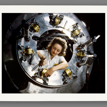A vintage photograph of a woman working on a plane part, as it would look when printed on fine art paper
