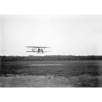 A vintage, black and white photograph of a Wright Biplane flying over College Park Aviation Field